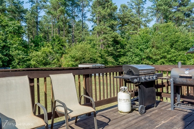 2575 Collier Road Forsyth, GA 31029 - Photo 5 of 25 a balcony with wooden floor table and chairs