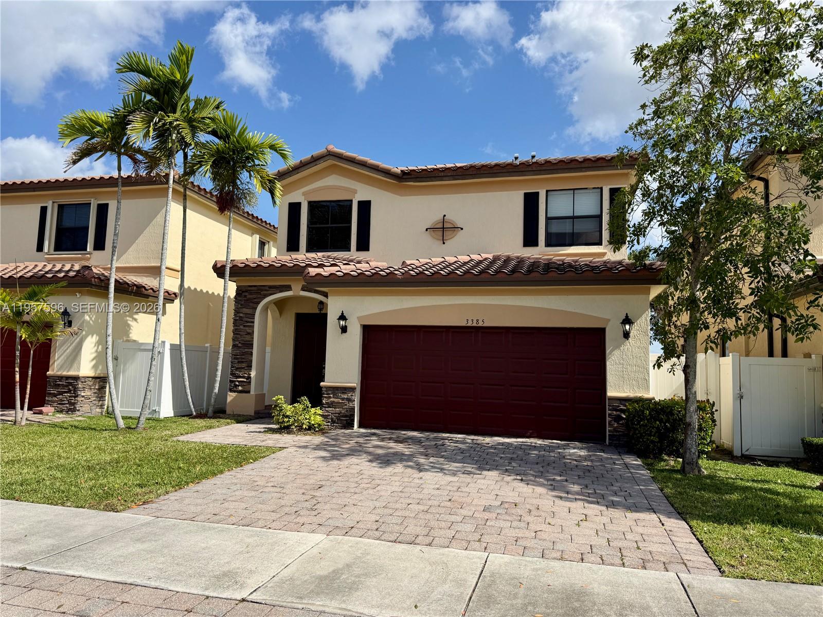 3385 West 86th Terrace, Unit 3385 Hialeah, FL 33018 - Photo 1 of 19 a front view of a house with a yard and garage