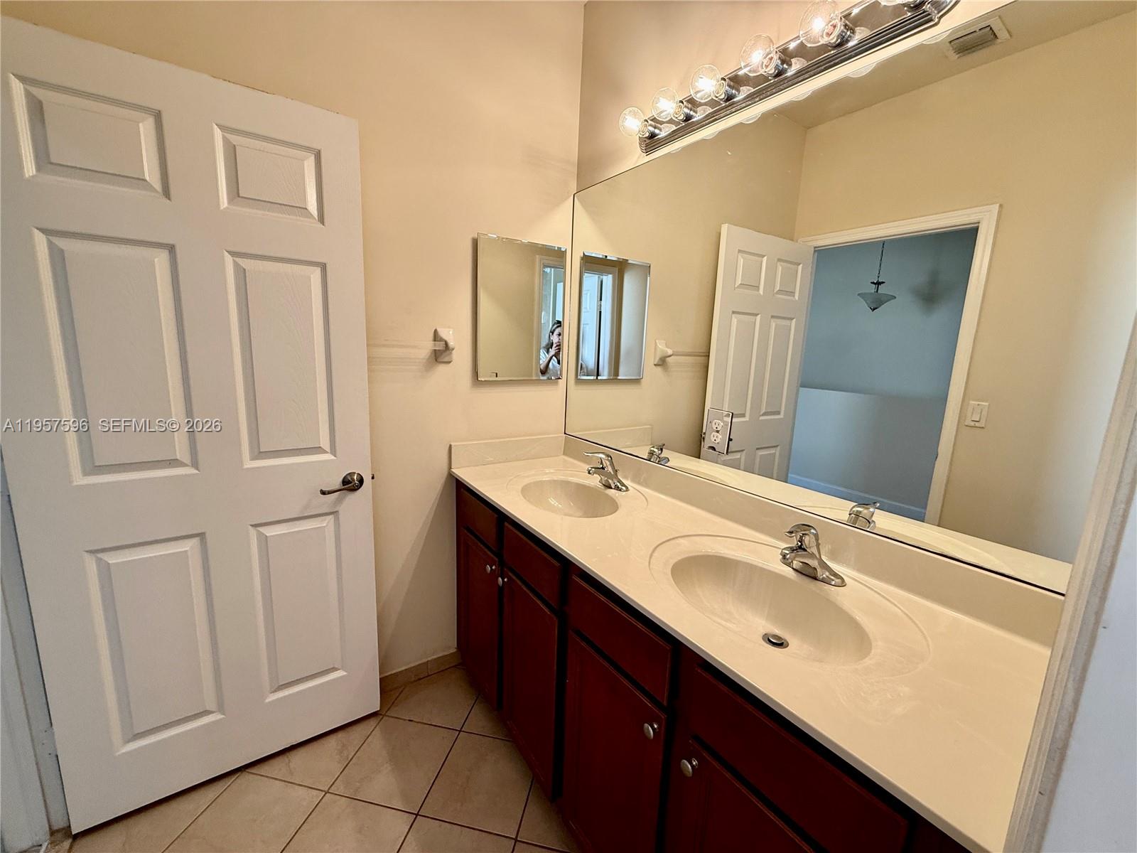 3385 West 86th Terrace, Unit 3385 Hialeah, FL 33018 - Photo 11 of 19 a bathroom with a double vanity sink a and mirror