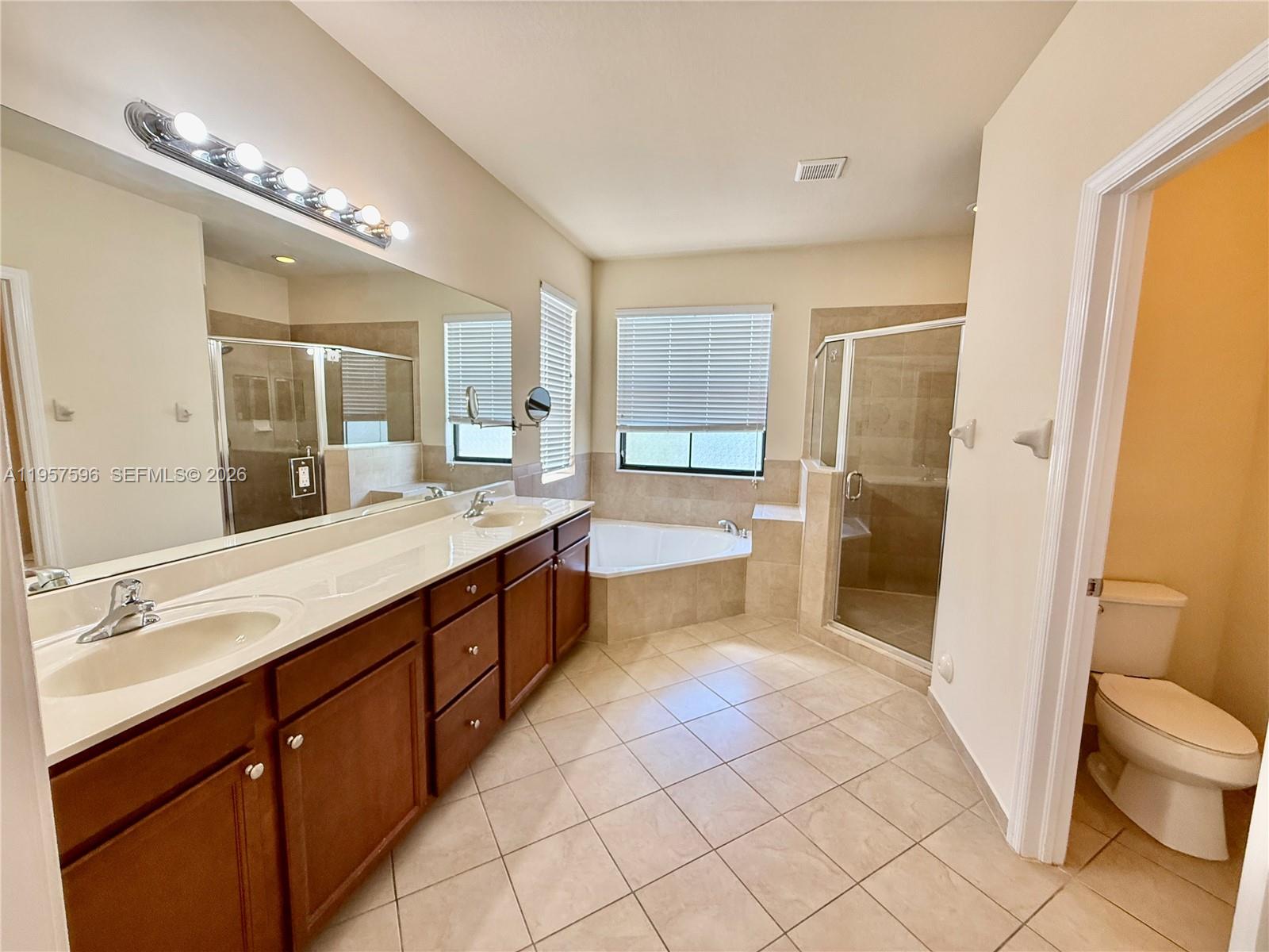 3385 West 86th Terrace, Unit 3385 Hialeah, FL 33018 - Photo 16 of 19 a spacious bathroom with a granite countertop sink mirror and a bathtub
