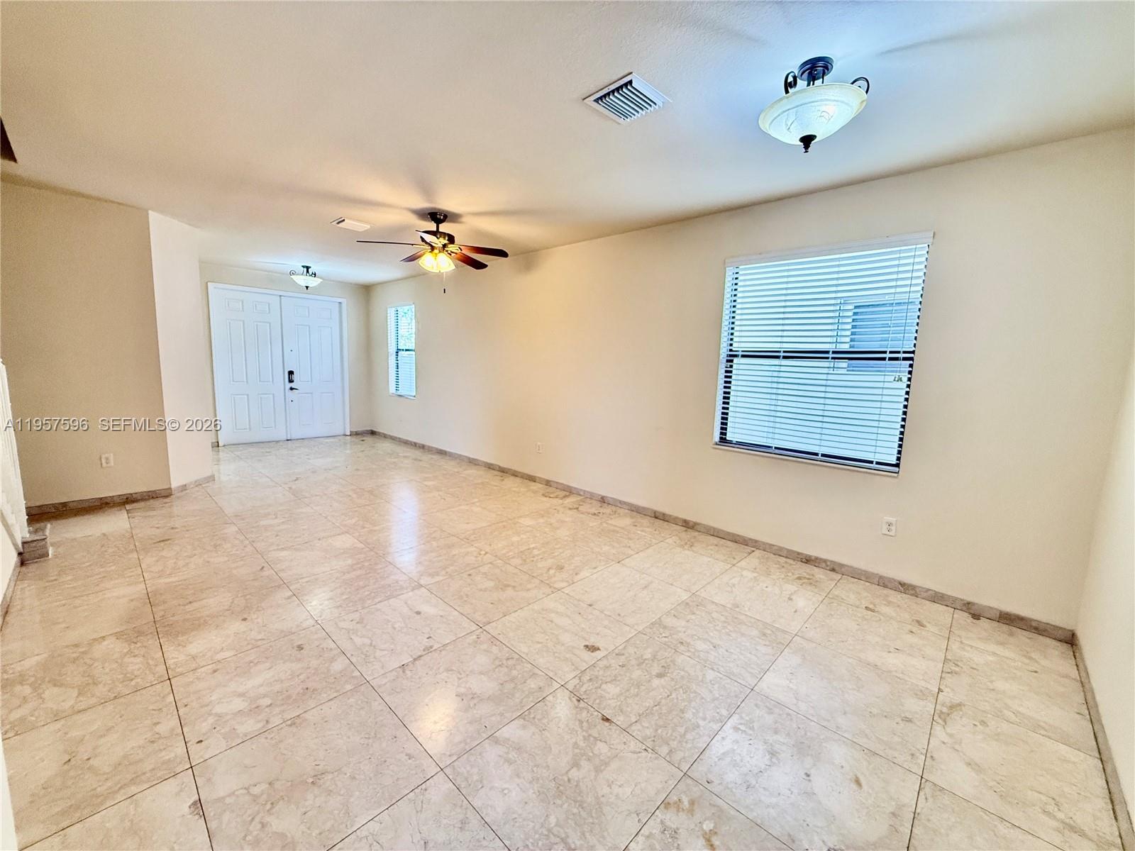 3385 West 86th Terrace, Unit 3385 Hialeah, FL 33018 - Photo 4 of 19 an empty room with fan and windows
