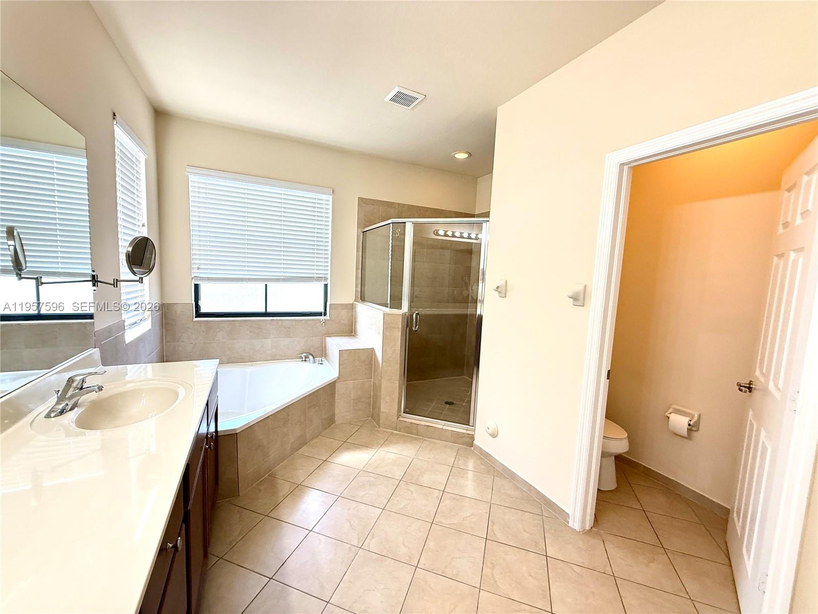 3385 West 86th Terrace, Unit 3385 Hialeah, FL 33018 - Photo 6 of 19 a spacious bathroom with a tub sink and a mirror