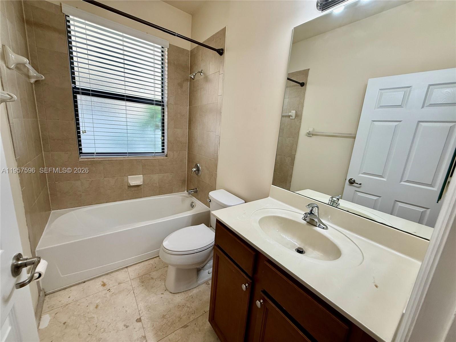 3385 West 86th Terrace, Unit 3385 Hialeah, FL 33018 - Photo 7 of 19 a bathroom with a sink a toilet and bathtub