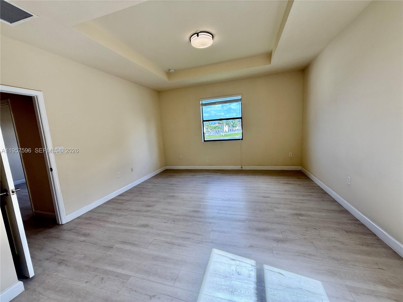 3385 West 86th Terrace, Unit 3385 Hialeah, FL 33018 - Photo 8 of 19 an empty room with wooden floor and window