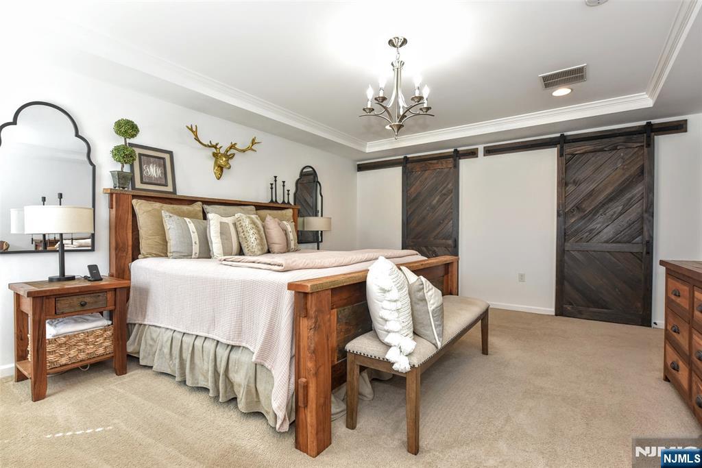 28 Autumn Way, Unit 72 Montvale, NJ 07645 - Photo 25 of 34 a bed room with a bed and a chandelier