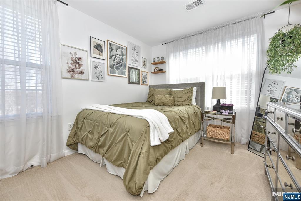 28 Autumn Way, Unit 72 Montvale, NJ 07645 - Photo 29 of 34 a bedroom with a bed and a flat tv screen