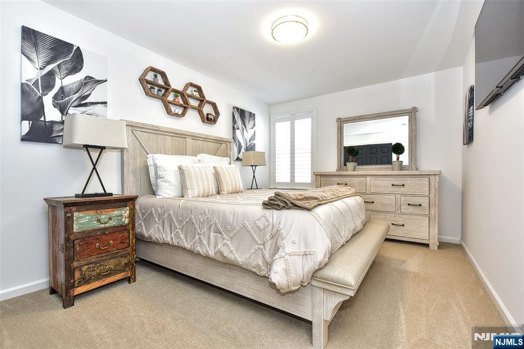28 Autumn Way, Unit 72 Montvale, NJ 07645 - Photo 31 of 34 a bedroom with a bed and a flat tv screen on the dresser