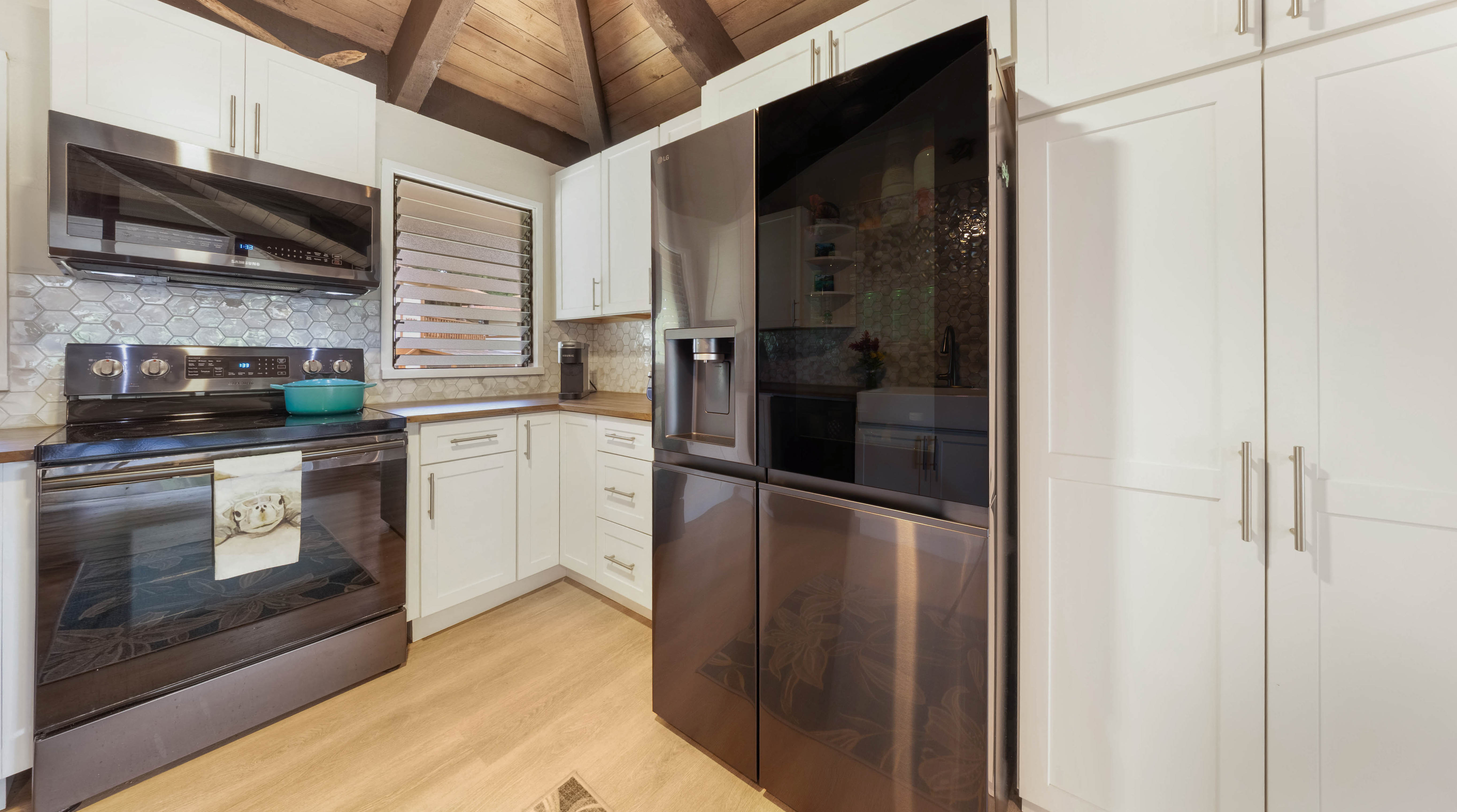 4701 Kawaihau Road, Unit L201 Kapaa, HI 96746 - Photo 6 of 29 a kitchen with stainless steel appliances granite countertop a stove a refrigerator and a microwave