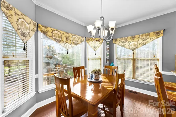 a view of a dining room with furniture large windows and wooden floor