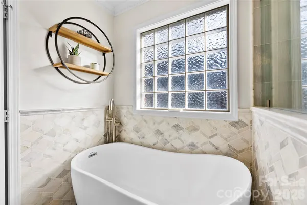a bathroom with a bathtub and a window