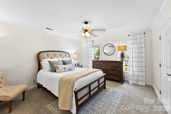 a bedroom with a bed a chandelier and a window