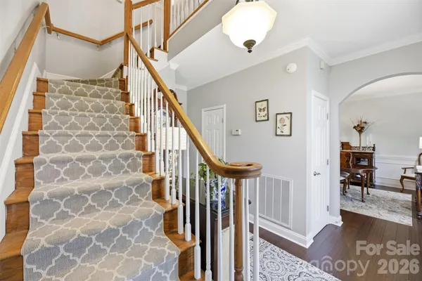 a view of a hallway with wooden floor and staircase