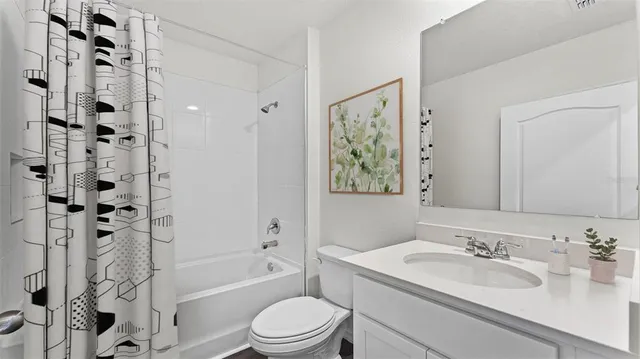a bathroom with a granite countertop sink toilet a mirror a vanity and shower