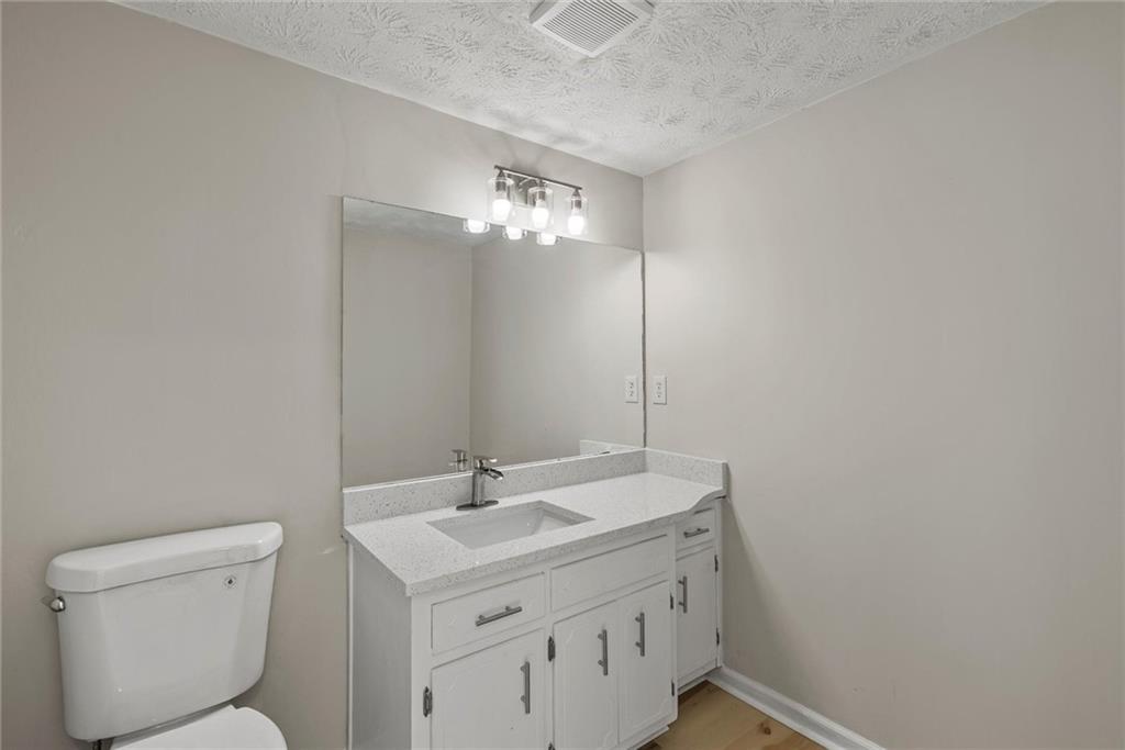 3428 Runelle Place Southwest Lilburn, GA 30047 - Photo 18 of 36 a bathroom with a sink a toilet and a mirror