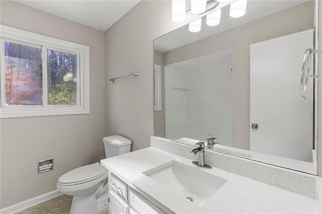 3428 Runelle Place Southwest Lilburn, GA 30047 - Photo 24 of 36 a bathroom with a sink a toilet and a mirror