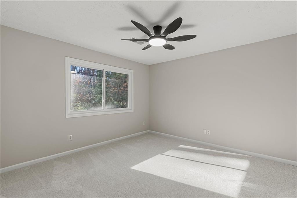 3428 Runelle Place Southwest Lilburn, GA 30047 - Photo 25 of 36 an empty room with a window and a fan
