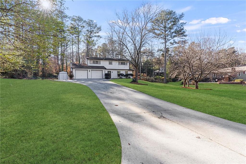 3428 Runelle Place Southwest Lilburn, GA 30047 - Photo 32 of 36 a view of a house with a big yard and large trees