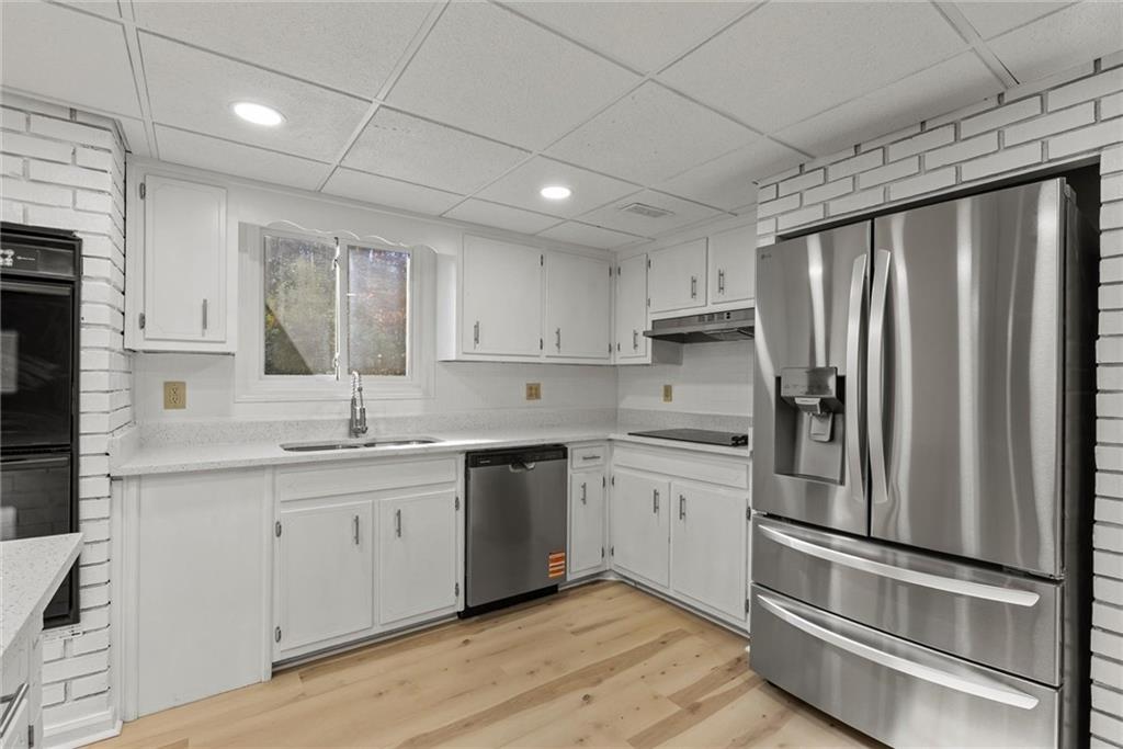 3428 Runelle Place Southwest Lilburn, GA 30047 - Photo 5 of 36 a kitchen with stainless steel appliances granite countertop a refrigerator sink and cabinets