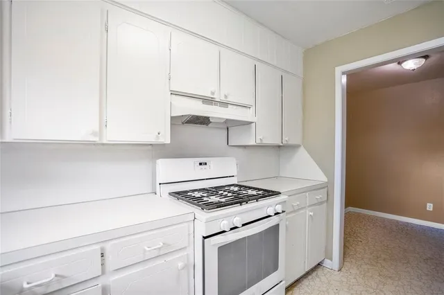 a kitchen with white cabinets and white appliances