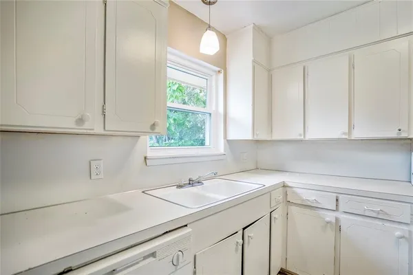 a kitchen with a sink cabinets and window