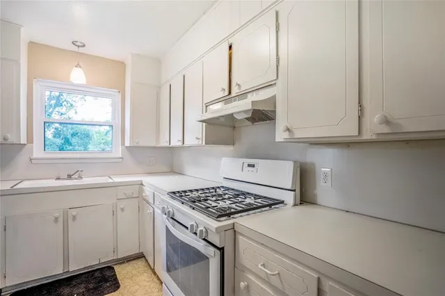 a kitchen with white cabinets and appliances