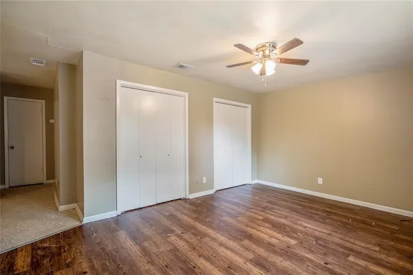a view of an empty room with wooden floor
