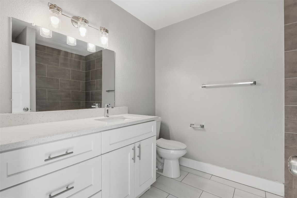 5106 Nuckols Crossing Road, Unit B Austin, TX 78744 - Photo 6 of 8 a bathroom with a granite countertop sink a toilet and shower