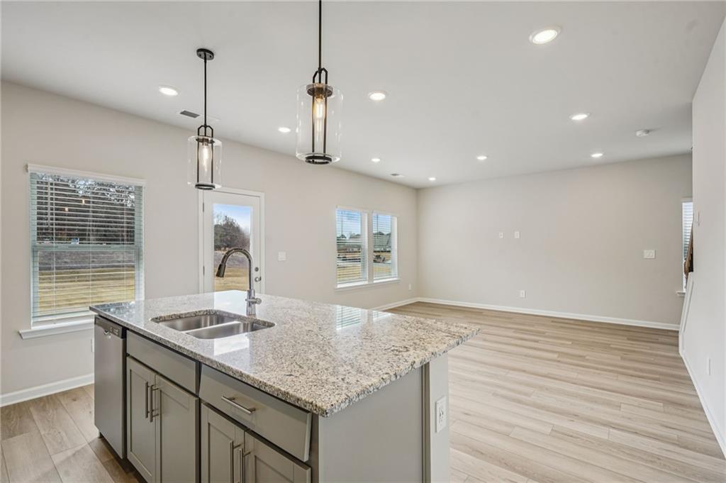 2004 Nolan Way Conyers, GA 30013 - Photo 10 of 23 a kitchen with stainless steel appliances granite countertop a sink a center island and wooden floor
