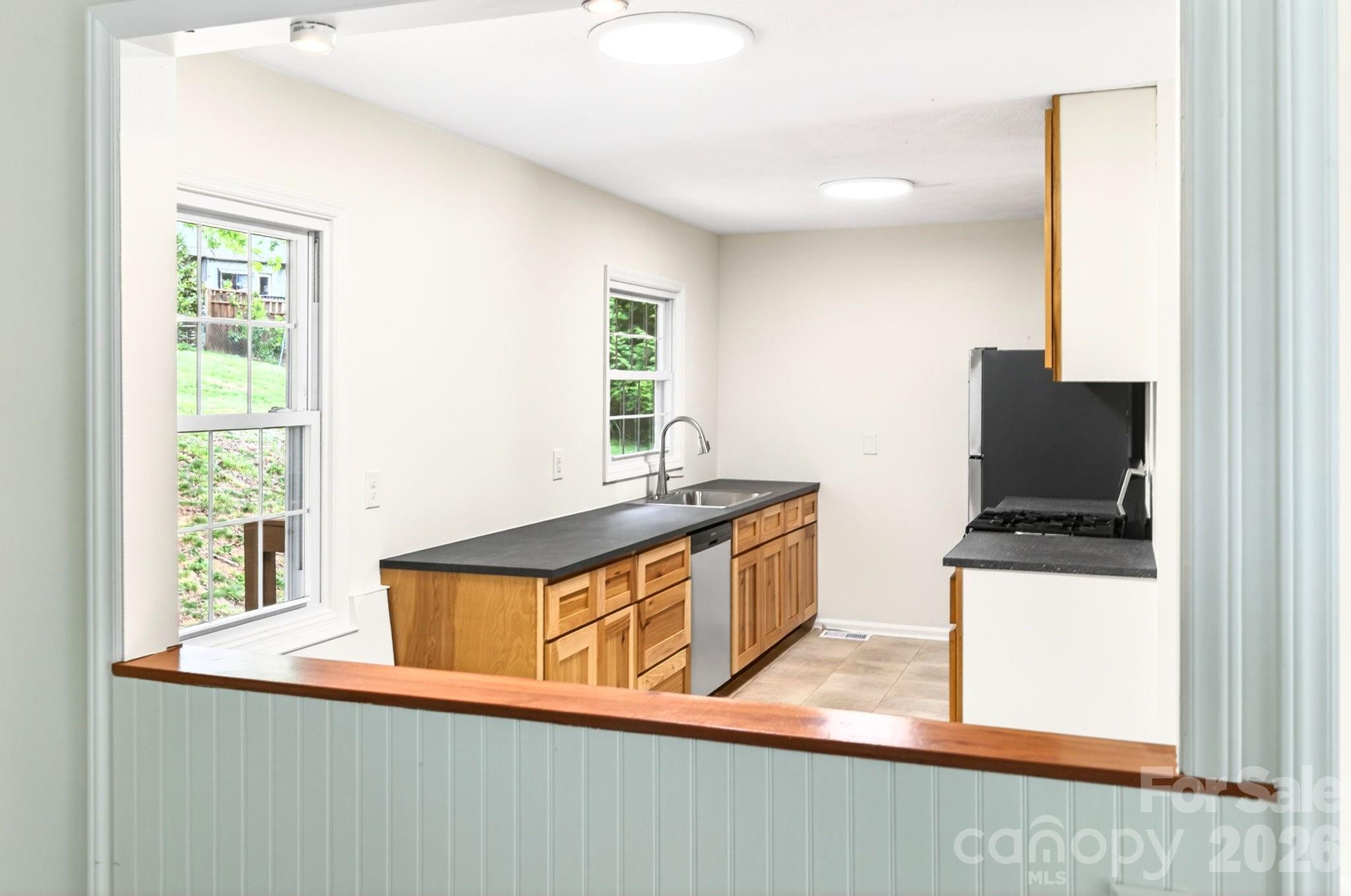 34 Wolfe Cove Road Asheville, NC 28804 - Photo 27 of 42 a kitchen with stainless steel appliances granite countertop a sink and a microwave
