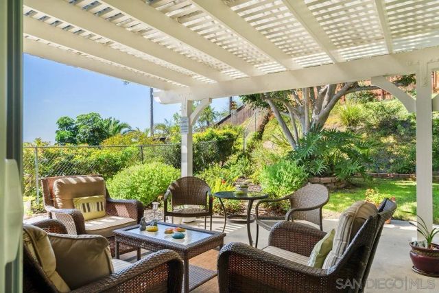 a view of swimming pool with lawn chairs and plants