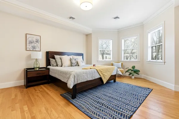 a bedroom with a bed and wooden floor