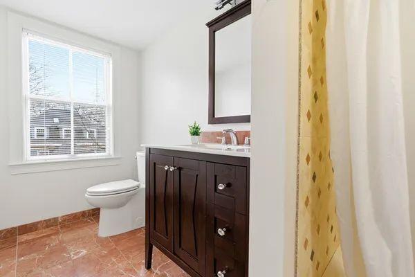 a bathroom with a sink a toilet and a window