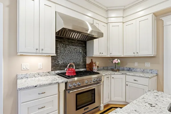 a kitchen with granite countertop a stove sink and cabinets