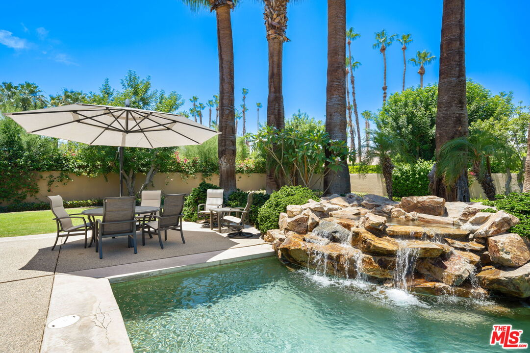 40590 Morningstar Road Rancho Mirage, CA 92270 - Photo 18 of 39 a view of a patio with table and chairs under an umbrella