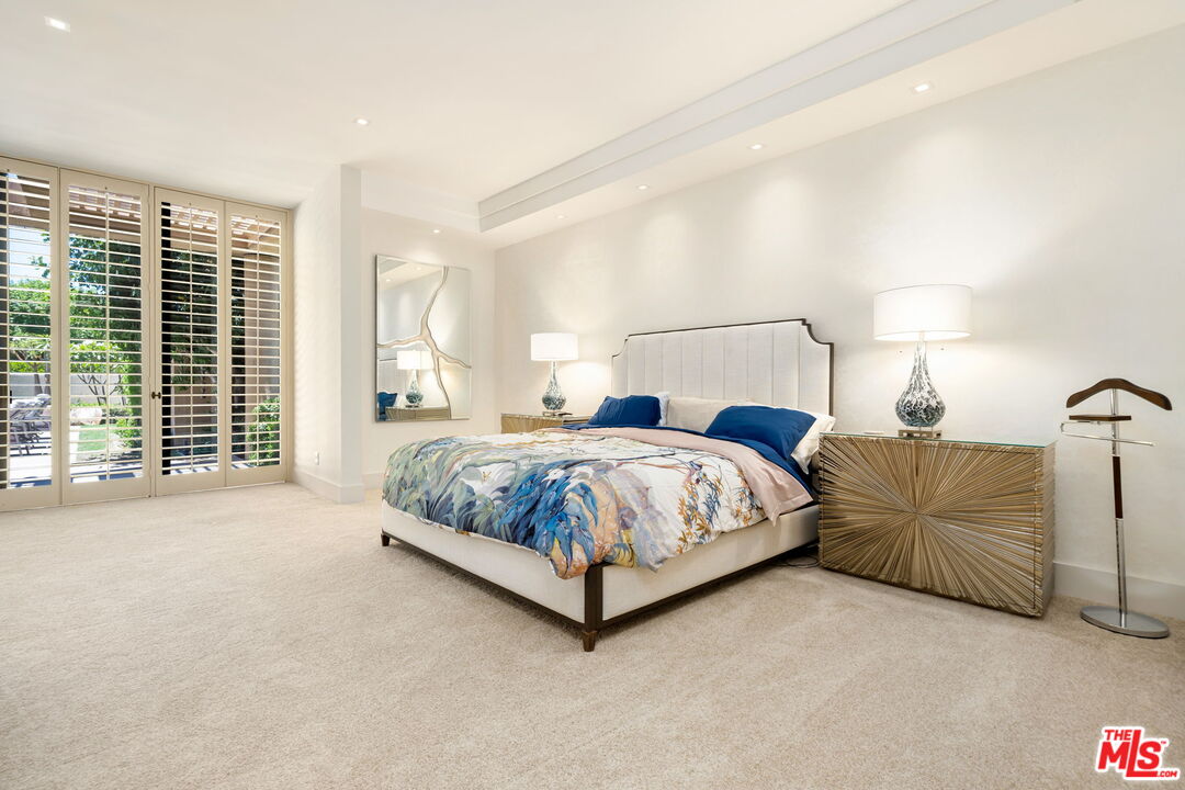 40590 Morningstar Road Rancho Mirage, CA 92270 - Photo 23 of 39 a spacious bedroom with a bed lamp and a large window