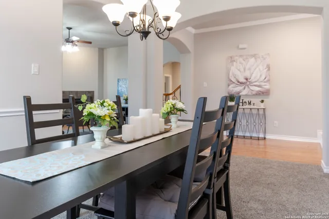 a dining room filled chandelier and wooden floor