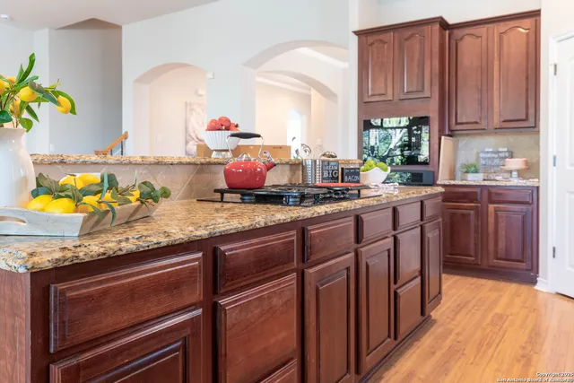 a kitchen with granite countertop stainless steel appliances a sink stove and cabinets