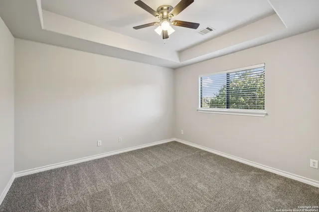 an empty room with a ceiling fan and closet