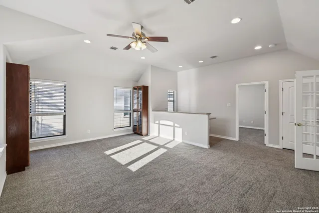 an empty room with windows and fan