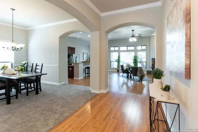 a view of a dining room and livingroom with furniture wooden floor a chandelier