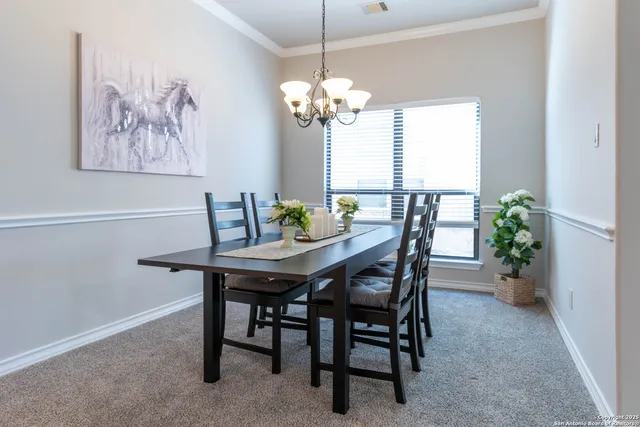 a view of a dining room with furniture and chandelier