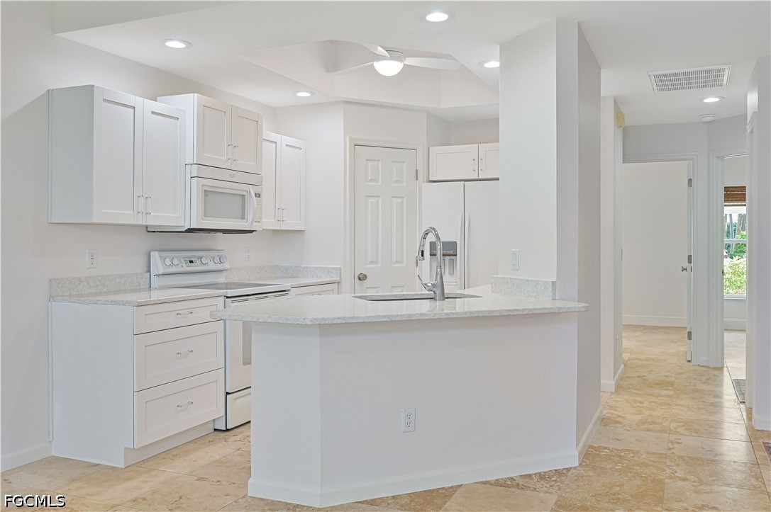 a kitchen with kitchen island white cabinets and refrigerator