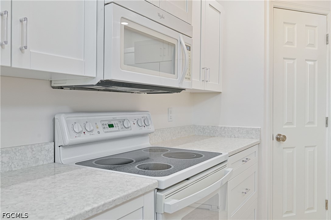 14967 Rivers Edge Court, Unit B1 Fort Myers, FL 33908 - Photo 14 of 36 a kitchen with white cabinets and a sink