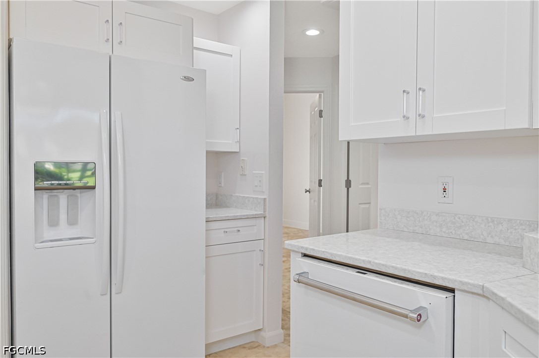 14967 Rivers Edge Court, Unit B1 Fort Myers, FL 33908 - Photo 15 of 36 a kitchen with white cabinets and a refrigerator