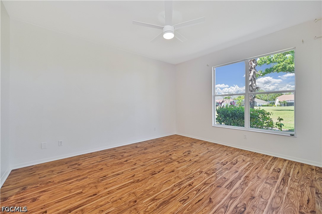 14967 Rivers Edge Court, Unit B1 Fort Myers, FL 33908 - Photo 22 of 36 a view of empty room with wooden floor and fan
