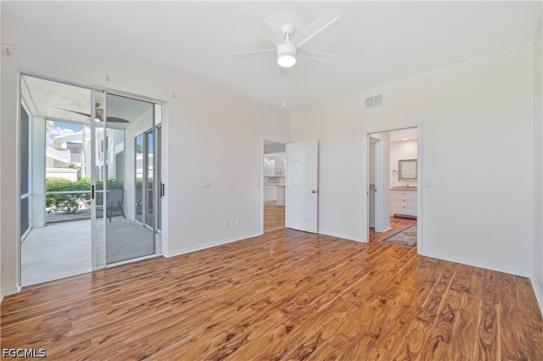 14967 Rivers Edge Court, Unit B1 Fort Myers, FL 33908 - Photo 23 of 36 a bedroom with a bed and a chandelier fan