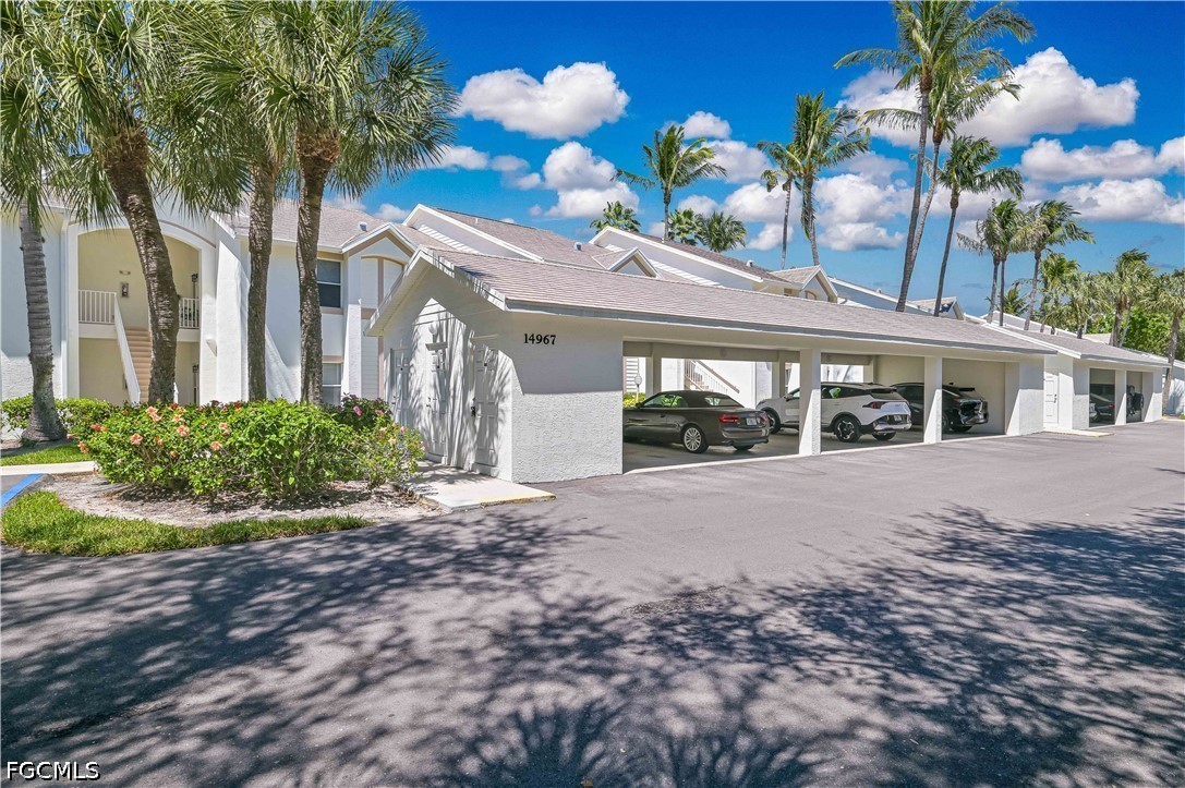 14967 Rivers Edge Court, Unit B1 Fort Myers, FL 33908 - Photo 31 of 36 a front view of a house with a yard and potted plants