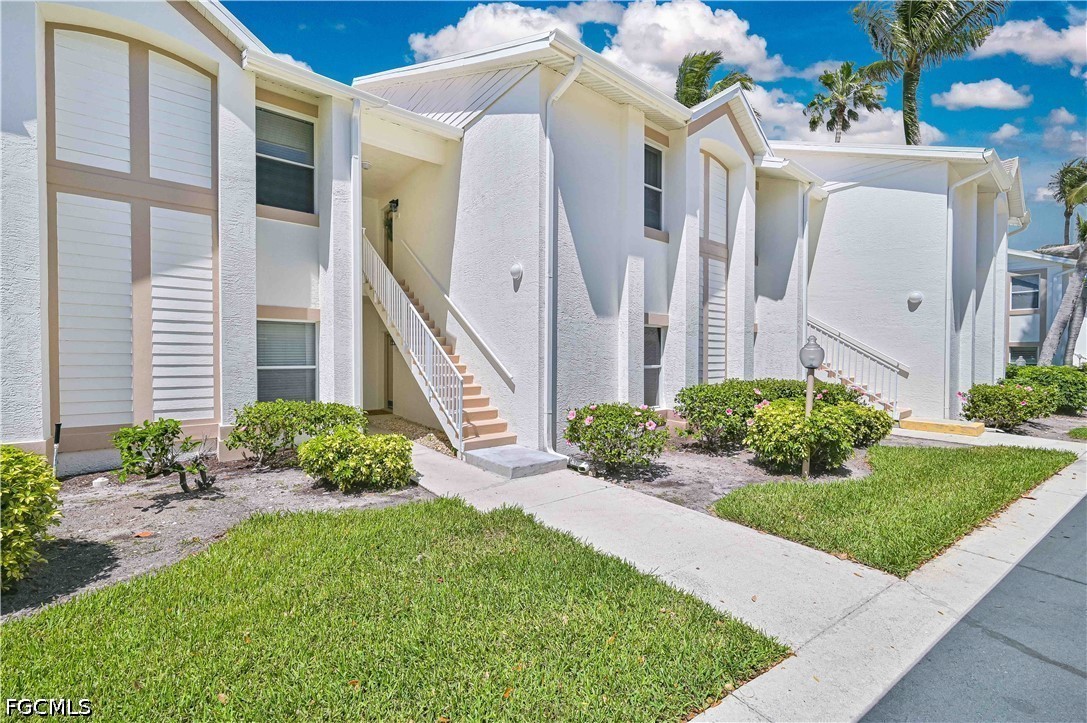 14967 Rivers Edge Court, Unit B1 Fort Myers, FL 33908 - Photo 4 of 36 a front view of a house with a yard