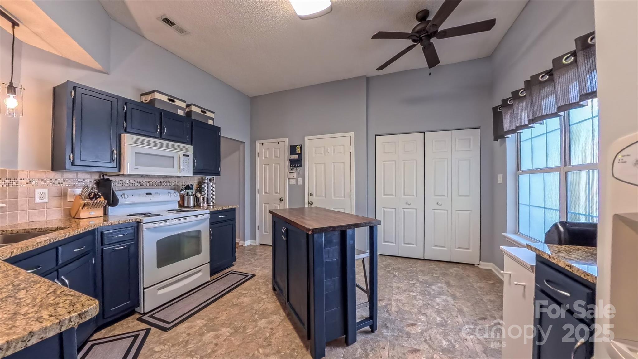 3693 Stonefield Street Southwest Concord, NC 28027 - Photo 13 of 27 a kitchen with a stove sink and a refrigerator