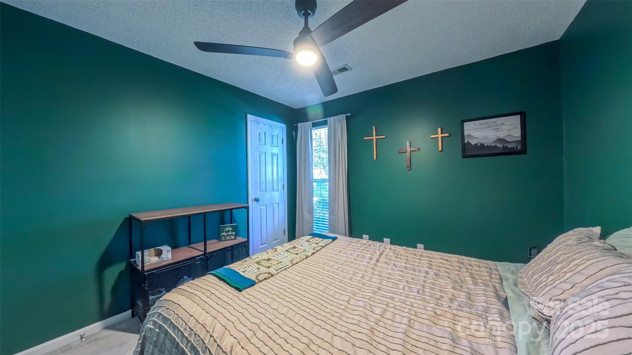 3693 Stonefield Street Southwest Concord, NC 28027 - Photo 18 of 27 a bedroom with a bed and a chandelier